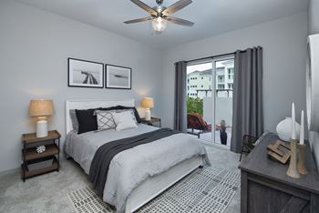 Bedroom with carpeting and large window at Harrison Apartments, Florida